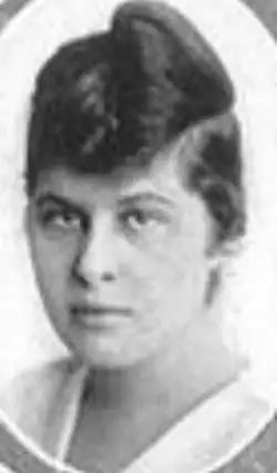 A young white woman with dark hair in an unusual asymmetrical updo, in an oval frame
