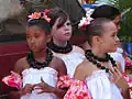 Young hula dancers wearing kukui nut lei in preparation for a performance on Molokai.