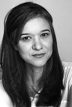 Headshot of Boushnak looking into camera. Long, dark hair. Black and white photo.