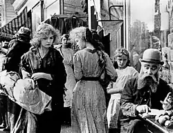 Black and white film still showing Lillian Gish and another woman on a street
