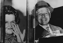 The Krogers, sitting in the back seat of a car, smiling broadly