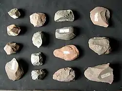 Stone tool artifacts include flakes, cores, and hammers used by hominins during the Paleolithic Period