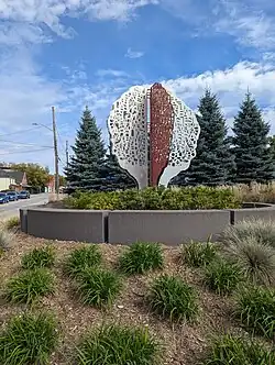 A public art sculpture that resembles a tree with many words among the branches