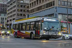 A bus with a blue bicycle in front