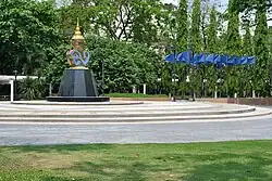 Round, outdoor area with blue flags and a statue