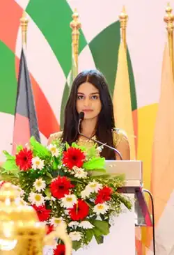 Photo of Dilhara behind a podium in 2018