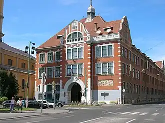 The school building - a large brownstone building in the middle of the city with a decorated facade.