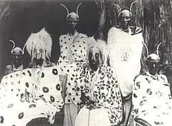 A family standing and sitting together, adorned with traditional regalia.