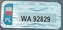 A holographic, rectangular sticker resembling a standard license plate. It reads WA92829