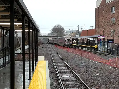 A passenger train leaving a small railway station