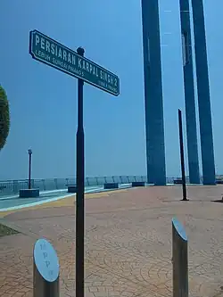 A road sign at Karpal Singh Drive, with the Celebration of Our Blue Sky installation in the background.