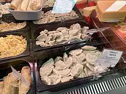 Fresh pierogi on display behind a deli counter
