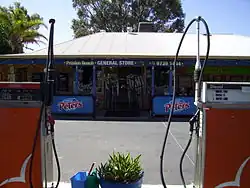 Photo of shop front behind two fuel pumps