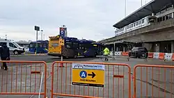 A Q121 A train shuttle bus dropping off people at the Howard Beach–JFK Airport station in 2025