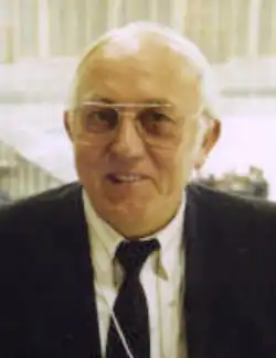 Color photo of Roman Neumayer wearing a black jacket and a white dress shirt