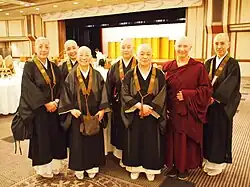 A group of Buddhist nuns with shaved heads smiling at the camera