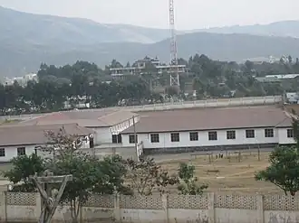 Aerial view of a school campus with hills in the background