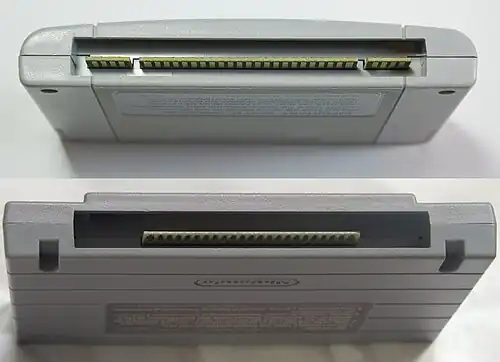 A photo showing the bottom ends of a PAL SNES / Japanese SFC cartridge and a North American SNES cartridge.
