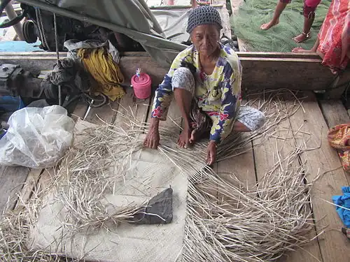 A Sama woman making a traditional mat (tepoh) from pandan leaves in Semporna, Sabah, Malaysia