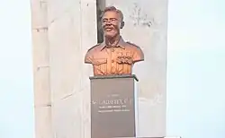 A metal bust of Cornelius Francis Adjetey from the chest up, on a stone pedestal