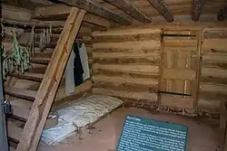 Photograph showing single bedding on a pallet on a dirt floor