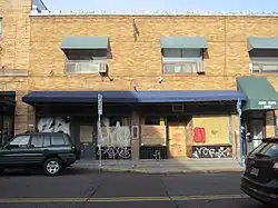 Photograph of the exterior of a two-story brick building from across the street