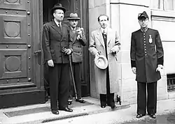 Four men standing outside the Federal Palace of Switzerland in 1943. From left is Franz Joseph II, Marcel Pilet-Golaz, Enrico Celio, and an unknown guard.