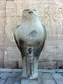 One of two statues of the falcon god Horus behind a smaller depiction of Caesarion at the Temple of Edfu in Edfu, Upper Egypt[28]