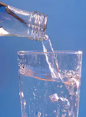 Water flowing from a bottle into a glass.