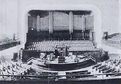 A view looking down from the balcony to the seating, rostrum and pipe organ in the church.