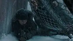 Abby crawls as an infected horde crushes her through a fence