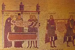 A mosaic with two scenes. Four white men in robes labeled as THEODOR' PBR, STAVRACIVS MON, TRIBVN' and RVSTIC' hold the body of a haloed closed-eyes bearded man in white robes labeled as S MARCS. In the second scene, TRIBVN' and RVSTIC' hold a stick on their shoulders. A full basket hangs from the stick.