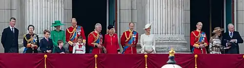 Senior members of the royal family standing on the balcony and waving to the crowd