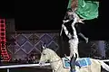 Turkmen man and his son hoist the flag of Turkmenistan while on horseback at the opening ceremony for the 2008 World Nomad Games.