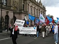 Street demonstration with banners, passing an official building