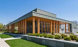 A one-story building of gray stone and red wooden beams