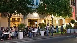 People sitting at tables near a street