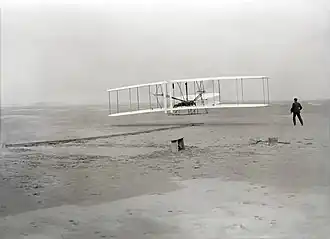 An airplane flying on a beach (from Human history)