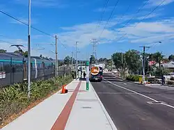 A bus interchange on the right with a bus and railway tracks on the left with a train