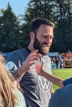 Bearded man high fiving a child after a match